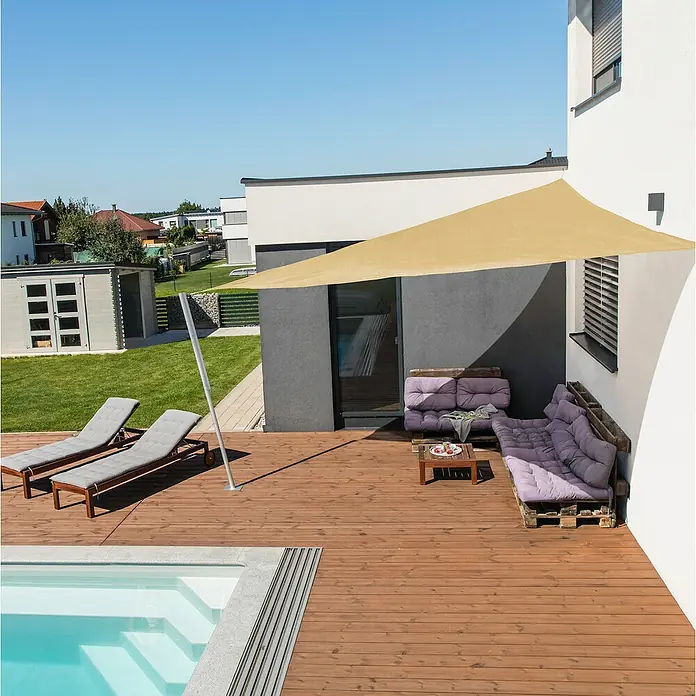 Windhager Sonnensegel Capri - L x B: 5 x 5 m, Champagner, Dreieckig - Ein sonnensegelgesäumter Außenbereich mit einer Terrasse aus Holz, Liegestühlen und einem kleinen Pool. Ein gemütlicher Rückzugsort im Freien.