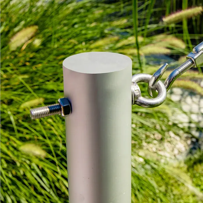 Windhager Ösenschraube - Durchmesser: 17 mm, Länge: 100 mm, Edelstahl - Nahaufnahme einer silbernen Metallsäule mit Bolzen und Haken vor einem Hintergrund aus grünem Gras.
