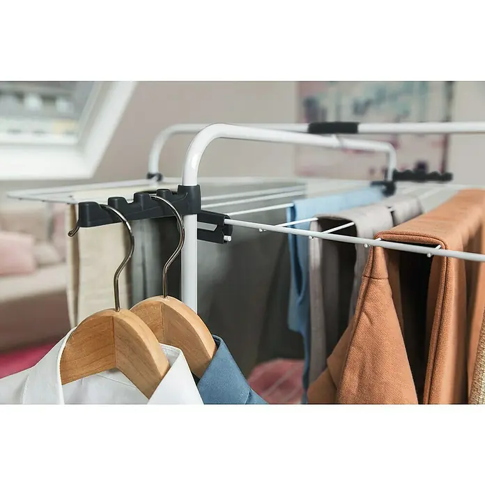 Vileda Turm-Wäscheständer Level 3 - Länge Wäscheleine: 33 m, L x B x H: 69 x 74 x 130 cm, Weiß/Anthrazitgrau - Nahaufnahme eines Wäscheständers mit Hemden und Hosen, der ideal zum Trocknen von Kleidung ist. Der Wäscheständer ist robust und praktisch.