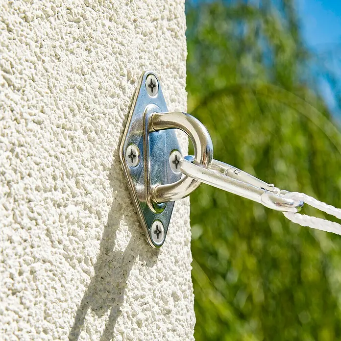 Windhager Halte-Öse - Geeignet für: Sonnensegel, Edelstahl, Silber - Eine Nahaufnahme einer quadratischen, an einer weißen Wand befestigten Ösenplatte aus Metall, die mit einem Karabiner verbunden ist.