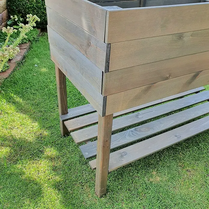 Promadino Kräuterhochbeet - L x B x H: 100 x 50 x 80 cm, Grau - Nahaufnahme eines erhöhten Hochbeets aus Holz mit einer Ablagefläche im Garten, ideal für den Anbau von Pflanzen und Gemüse.