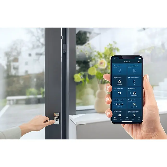 Bosch Smart Home Funk-Fensterkontakt II - Anthrazit, Batteriebetrieben, 23 x 22 x 75 mm, 1 Stk. - Smarte Haustechnik: Ein Smartphone zeigt die Steuerung des Sicherheitssystems und anderer Hausfunktionen neben einer Tür.