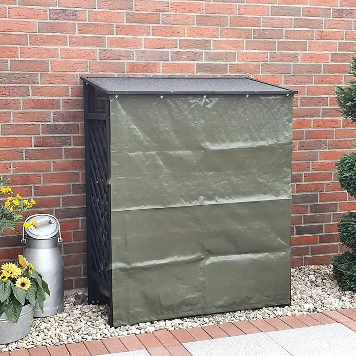 Promadino Kaminholzregal Speyer mit Wetterschutz - 120 x 68 x 148 cm, Anthrazit - Außenaufnahme einer Mülltonnenbox mit olivgrüner Plane vor einer Ziegelwand und Blumenkübel.
