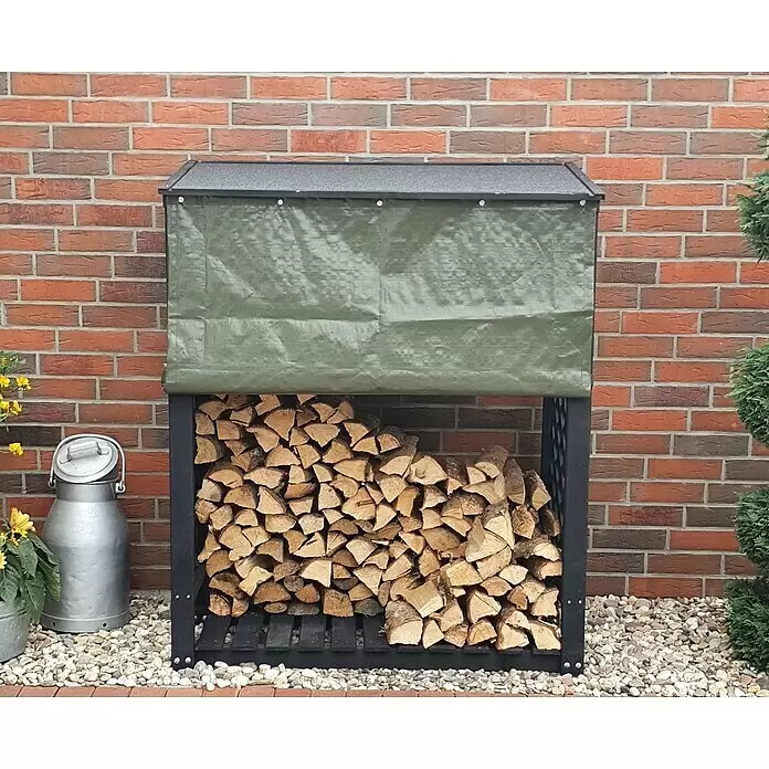 Promadino Kaminholzregal Speyer mit Wetterschutz - 120 x 68 x 148 cm, Anthrazit - Schwarzes Metall-Kaminholzregal mit Holz, dunkelgrauem Dach und aufgerollter grüner Plane, vor Ziegelwand.