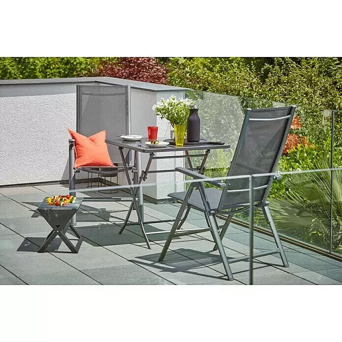 Grillstar Holzkohlegrill - Grillfläche (B x T): 44 x 29 cm, Schwarz - Ein modernes graues Terrassen-Ess-Set mit Tisch, zwei Stühlen und Beistelltisch mit Speisen auf einem Balkon.