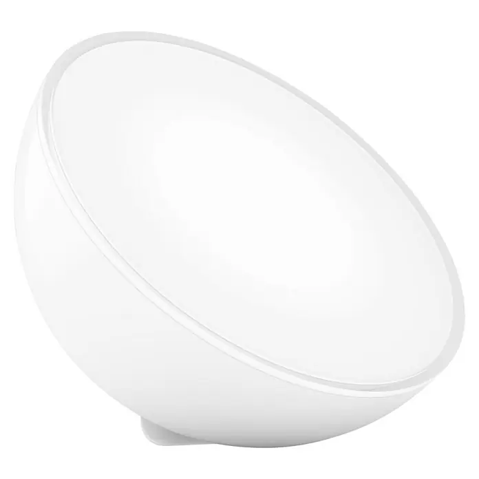 Philips Hue LED-Tischleuchte Go - 6 W, L x B x H: 15 x 15 x 7,9 cm, RGBW - Ein weißes, halbkugelförmiges Objekt, möglicherweise eine Lampe oder ein Diffusor, vor einem schwarzen Hintergrund. Das Objekt wirkt sanft beleuchtet.