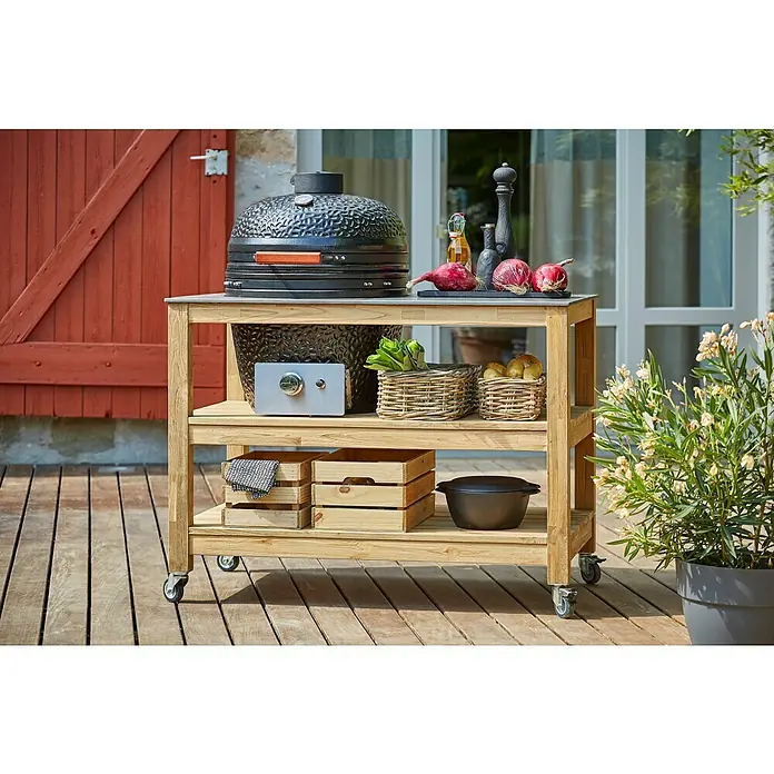 Sunfun Zoe Outdoorküchen-Modul Kamado - Braun, B x T x H: 120 x 71,5 x 89 cm, Teakholz - Outdoor-Szene mit einem Kamado-Grill auf einem stilvollen Servierwagen mit Arbeitsfläche und Regalböden für Zubehör und Zutaten.