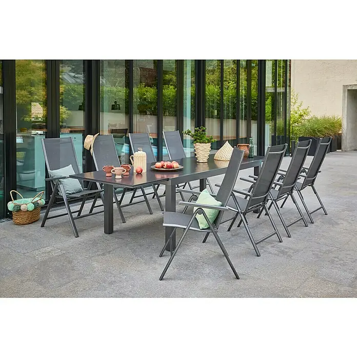Sunfun Maja Slim Garten-Positionssessel - Aluminium/Textilene, Rückenlehne verstellbar, Anthrazit, B x T x H: 67 x 58 x 110 cm - Bild von einem anthrazitfarbenen Gartentisch-Set mit Metallrahmen und dazu passenden Stühlen auf einer Terrasse.