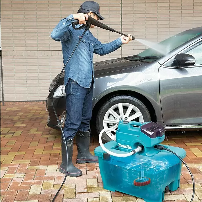 Makita LXT 18V Akku-Hochdruckreiniger DHW080ZK - 36 V, Ohne Akku, 80 bar, Fördermenge: 380 l/h - Türkisfarbener tragbarer Makita Hochdruckreiniger mit lila Akzenten, wird von einer Person zum Reinigen eines grauen Autos verwendet.