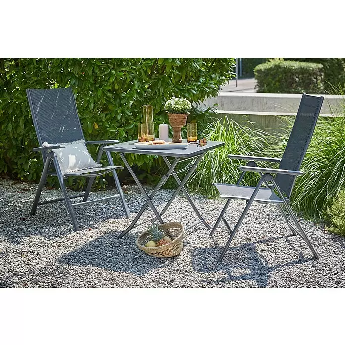 Sunfun Maja Slim Garten-Positionssessel - Aluminium/Textilene, Rückenlehne verstellbar, Anthrazit, B x T x H: 67 x 58 x 110 cm - Dunkelgraue Klapptischgarnitur aus Metall mit zwei passenden Stühlen mit Netzbespannung, auf einer Kiesterrasse für entspanntes Draußenleben.