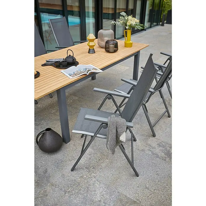 Sunfun Maja Slim Garten-Positionssessel - Aluminium/Textilene, Rückenlehne verstellbar, Anthrazit, B x T x H: 67 x 58 x 110 cm - Einladender Außenbereich mit Esstisch und Gartenstühlen. Der Tisch ist dekoriert, und die Stühle laden zum Verweilen ein.