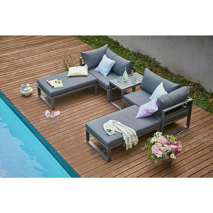 Sunfun Maja Loungemöbel-Set - 5 -tlg., Aluminium, Anthrazit - Einladende Gartengarnitur mit grauen Polstern und einem Beistelltisch auf einer Holzterrasse neben einem Pool. Perfekt zum Entspannen im Freien.