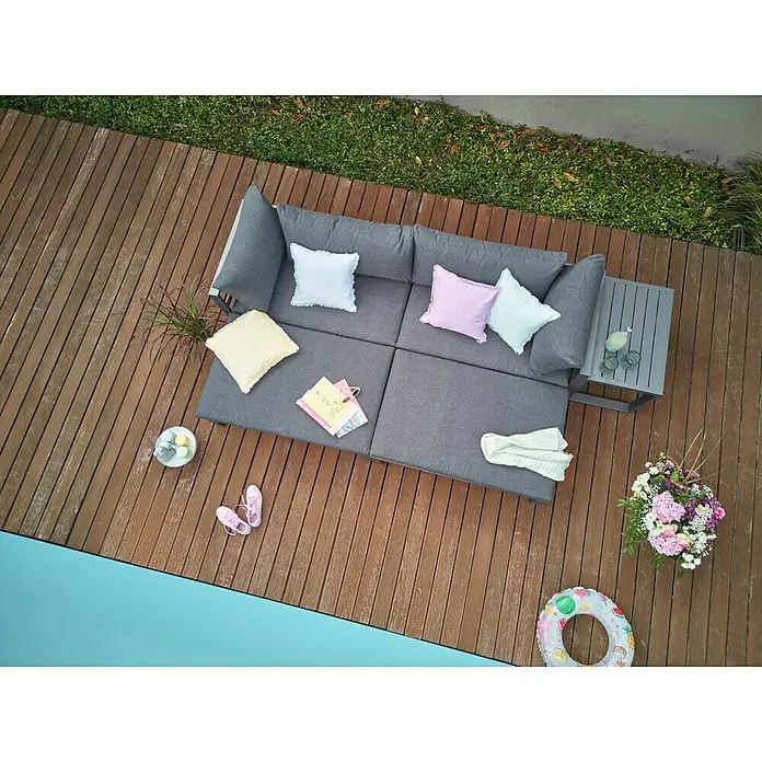 Sunfun Maja Loungemöbel-Set - 5 -tlg., Aluminium, Anthrazit - Luftaufnahme einer grauen modularen Terrassencouch mit Kissen, Beistelltisch und Dekoration auf einem Holzdeck neben einem Pool.