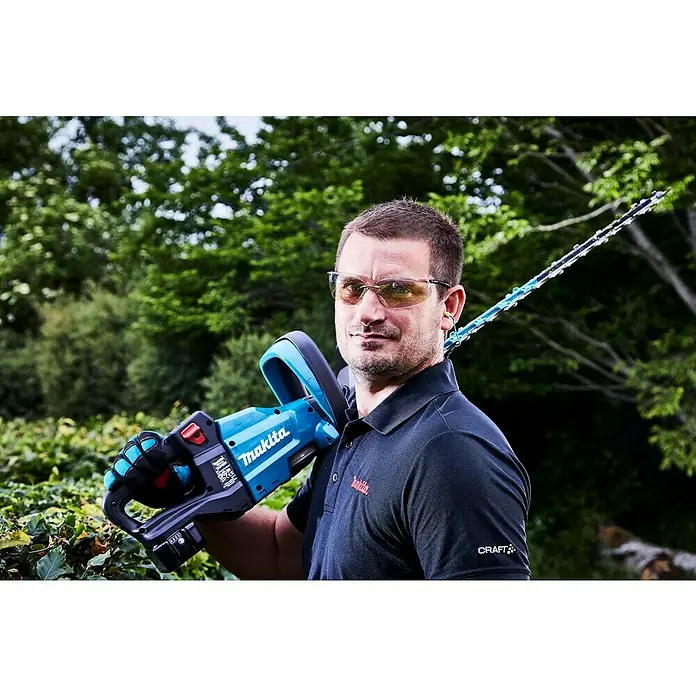 Makita LXT 18V Akku-Heckenschere DUH601Z - 18 V, Li-Ionen, Ohne Akku - Mann mit Makita Akku-Heckenschere, die für den perfekten Heckenschnitt sorgt. Ideal für jeden Gartenliebhaber, der Wert auf Qualität und Leistung legt.