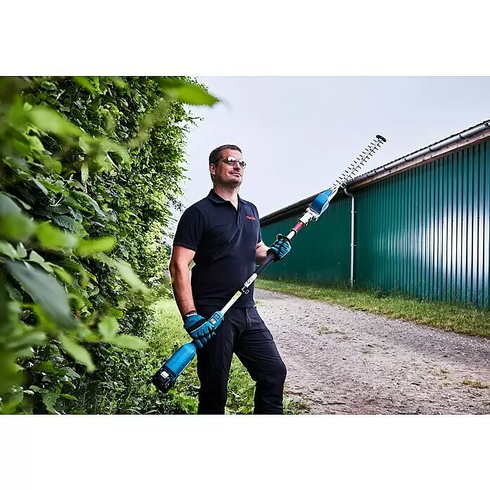 Makita LXT 18V Akku-Heckenschere DUN500WZ - 18 V, Li-Ionen, Ohne Akku - Mann in Schutzausrüstung hält eine blau-silberne Stielheckenschere zur Heckenpflege.