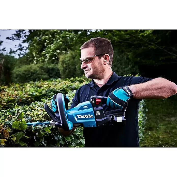 Makita LXT 18V Akku-Heckenschere DUH601Z - 18 V, Li-Ionen, Ohne Akku - Mann trimmt mit blauer und schwarzer Makita Heckenschere eine grüne Hecke.