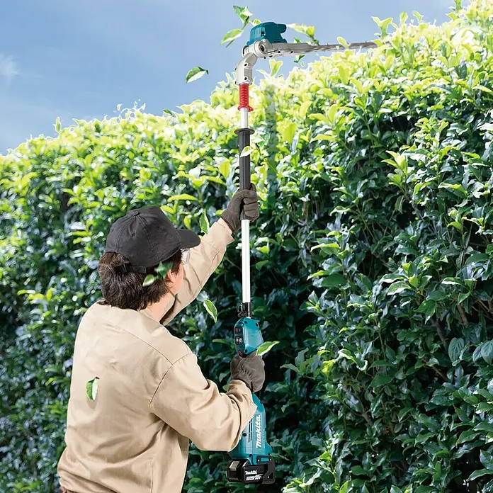 Makita LXT 18V Akku-Heckenschere DUN500WZ - 18 V, Li-Ionen, Ohne Akku - Ein Mann benutzt eine Makita Akku-Heckenschere mit Teleskopstiel, um eine Hecke zu schneiden. Ideal für hohe Hecken!