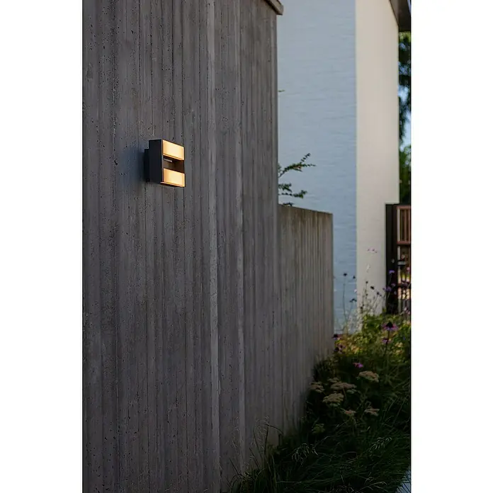 Lutec Conroy LED-Außenwandleuchte - 17,8 W, 22,5 x 15,5 x 9,7 cm, Anthrazit, IP44 - Moderne Außenleuchte an einer Betonwand. Die Leuchte strahlt warmes Licht aus und sorgt für eine stimmungsvolle Beleuchtung im Außenbereich.