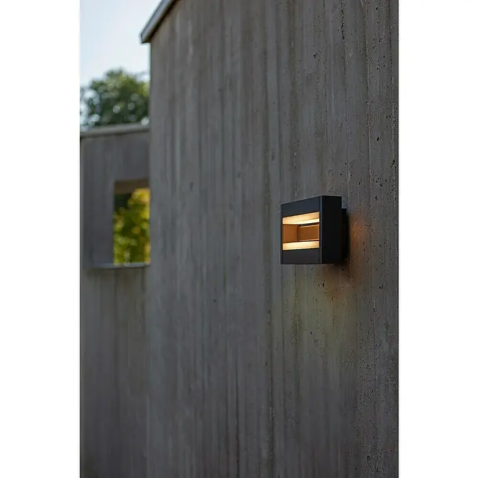Lutec Conroy LED-Außenwandleuchte - 17,8 W, 22,5 x 15,5 x 9,7 cm, Anthrazit, IP44 - Schwarze Außenwandleuchte mit horizontalen Lichtschlitzen an einer Betonwand, die elegantes, modernes Design und funktionale Beleuchtung vereint.