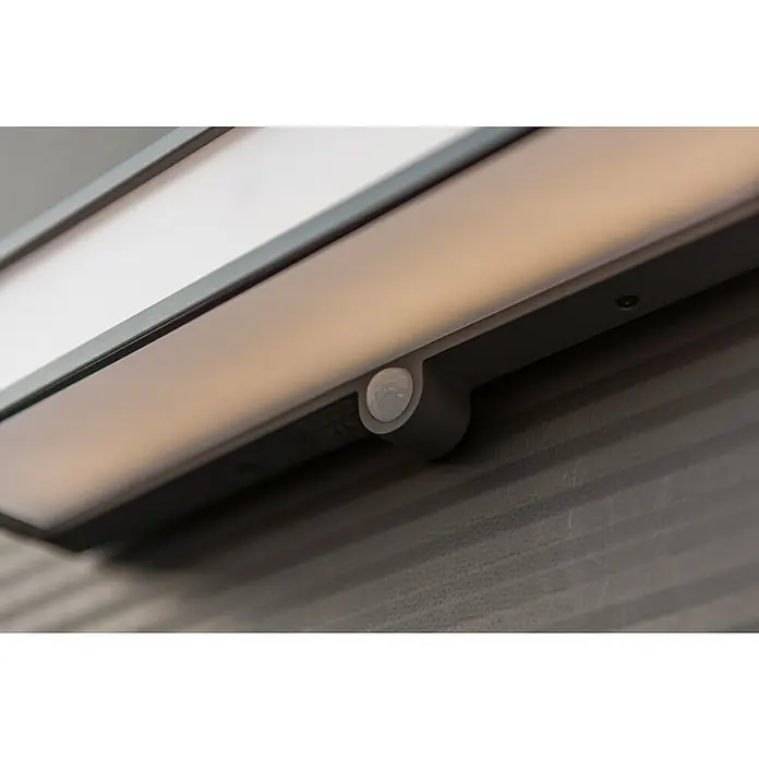 Lutec Doblo Solar-Außenwandleuchte - 16,5 W, L x B x H: 35 x 9,1 x 9 cm, Anthrazit, IP54, 1.800 lm - Eine Nahaufnahme einer LED-Leuchte mit Bewegungssensor unter einem Schrank. Die Leuchte ist schmal und rechteckig und strahlt ein warmes Licht ab.