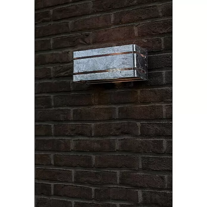 Lutec Außenwandleuchte Vidar - 40 W, 25 x 11,3 x 11 cm, Verzinkt, IP54 - Rechteckige graue Metall-Außenwandleuchte mit Kupferakzenten, an einer Ziegelwand montiert, strahlt Licht nach unten ab.
