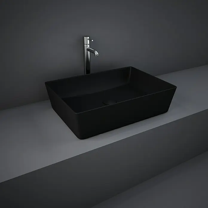 RAK Ceramics Feeling Aufsatzwaschbecken - 50 x 36 cm, Ohne Spezialglasur, Hahnloch: Ohne, Ohne Überlauf, Schwarz, Matt - Schwarzes, rechteckiges Waschbecken mit Chromarmatur. Elegantes Design für moderne Badezimmer, dunkler Hintergrund betont Form und Farbe.