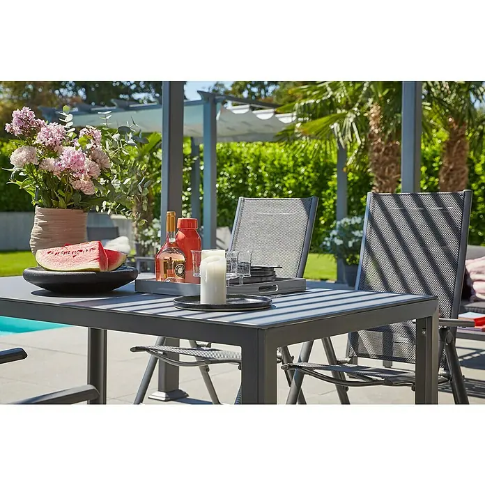Sunfun Maja Slim Garten-Positionssessel - Aluminium/Textilene, Rückenlehne verstellbar, Anthrazit, B x T x H: 67 x 58 x 110 cm - Gartentisch-Szene mit stilvollem Geschirr, Blumen und Getränken im Freien, die eine entspannte Atmosphäre für Mahlzeiten im Freien schafft.