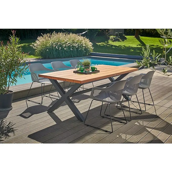 Gartenmöbel-Set Annika - 7 -tlg., Holz, Anthrazit/Schwarz/Flint Grey - Ein Gartentisch mit Stühlen auf einer Terrasse. Das Set ist ideal, um Mahlzeiten im Freien zu genießen und entspannte Stunden am Pool zu verbringen.