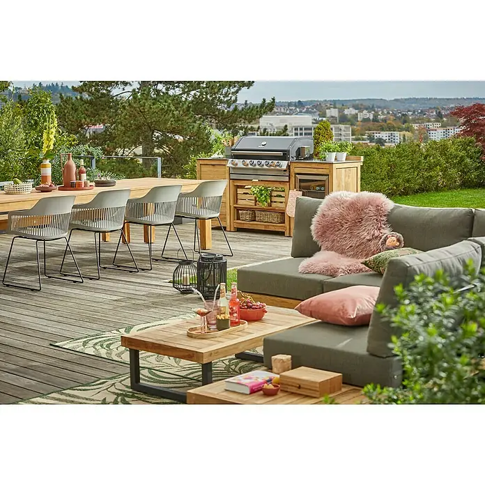 Sunfun Zoe Módulo de cocina exterior Armario con cajones - Marrón, An x Pr x Al: 58 x 63 x 92 cm, Madera de teca - Un espacio exterior elegante con una mesa de madera, sillas grises, una parrilla y un sofá cómodo, perfecto para relajarse al aire libre.