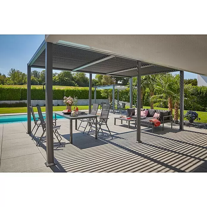 Sunfun Cannes Pergola - B x T: 540 x 300 cm, Farbe Gestell: Anthrazit, Aluminium - Dunkelgraue Lamellenpergola über einem Ess- und Loungebereich im Freien neben einem Pool, spendet Schatten.