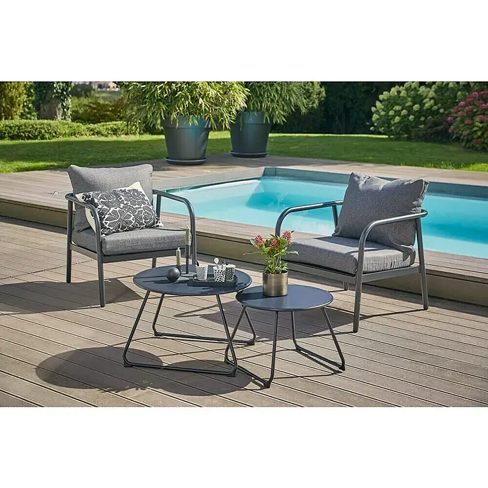 Loungesessel Olga - B x T x H: 67 x 76 x 63 cm, Schwarz/Grau - Gartenset mit zwei Stühlen und zwei Tischen auf einer Holzterrasse neben einem Pool. Ideal für entspannte Stunden im Freien.
