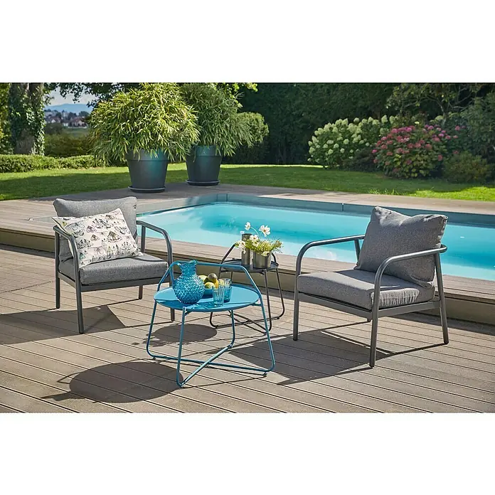 Loungesessel Olga - B x T x H: 67 x 76 x 63 cm, Schwarz/Grau - Gemütliche Gartenszene mit grauen Sesseln, einem blauen Tisch und Pool, perfekt für entspannte Stunden im Freien. Elegantes Design trifft auf Komfort.
