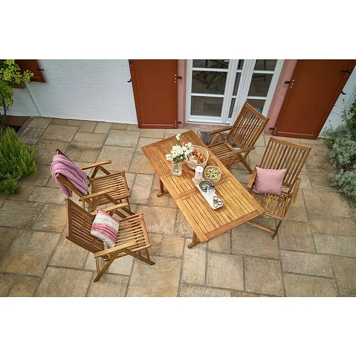 Sunfun Diana Gartentisch - L x B x H: 120 x 80 x 74 cm, Akazie, Rechteckig, Naturbraun - Ein Außenbereich mit einem Holztisch und passenden Stühlen, dekoriert mit Blumen, Brot und Kissen für eine entspannte Atmosphäre.