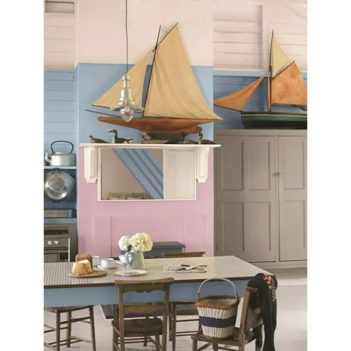 Bruguer Colores del Mundo Pintura para paredes - Nepal beige suave, Mate, 4 l - Comedor de inspiración náutica con modelos de barcos, paredes en tonos pastel y una mesa con mantel a cuadros para un ambiente marítimo.