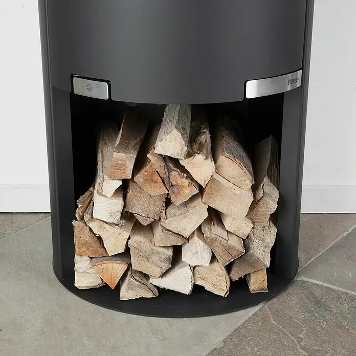 Aduro Kaminofen 1-4 - 6 kW, Raumheizvermögen: 334 m³, Material Verkleidung: Stahl, Schwarz - Nahaufnahme eines modernen Holzofens mit gestapeltem Holzscheit im unteren Fach, ideal für gemütliche Wärme und als stilvolles Wohndekor.