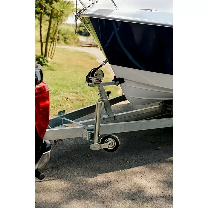 PEGAZUS GFK-Boot 550 Comfort - Umfangreiche Zusatzausstattung, Geeignet für: Max. 6 Personen, Nutzlast: 670 kg, CE-Klasse C - Weißblaues Boot auf silbernem Trailer mit Winde, am Fahrzeug befestigt, bereit zum Transport.
