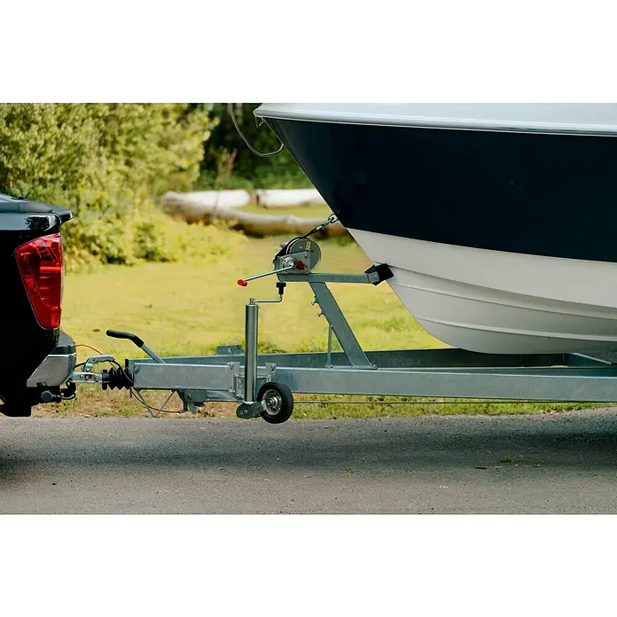 PEGAZUS GFK-Boot 550 Comfort - Umfangreiche Zusatzausstattung, Geeignet für: Max. 6 Personen, Nutzlast: 670 kg, CE-Klasse C - Naheaufnahme eines Bootstrailers, der an ein schwarzes Fahrzeug angekoppelt ist, ideal für den sicheren Transport von Wasserfahrzeugen.