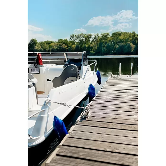 PEGAZUS GFK-Boot 550 Comfort - Umfangreiche Zusatzausstattung, Geeignet für: Max. 6 Personen, Nutzlast: 670 kg, CE-Klasse C - Weißes Boot mit blauen Fendern an einem Holzsteg auf einem ruhigen See, umgeben von grünen Bäumen.