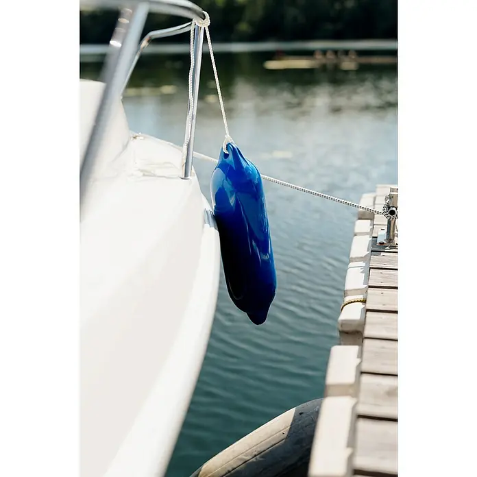 PEGAZUS GFK-Boot 550 Comfort - Umfangreiche Zusatzausstattung, Geeignet für: Max. 6 Personen, Nutzlast: 670 kg, CE-Klasse C - Eine Nahaufnahme eines blauen Fender, der an einem weißen Boot hängt, um den Kontakt mit dem Dock zu verhindern.