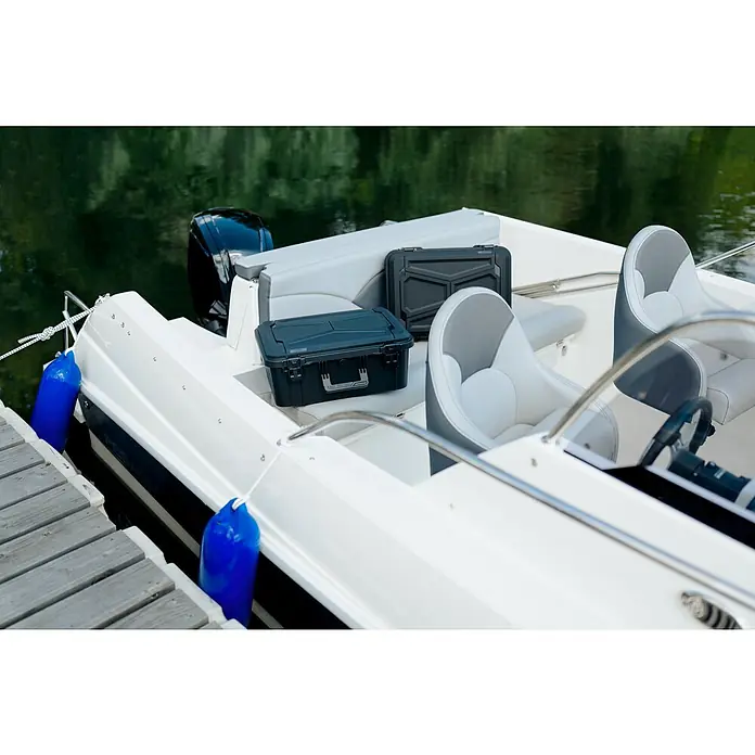 Wasserdichter Koffer EKO90 - L x B x H: 520 x 350 x 125 mm, Ohne Schaumstoffeinlage, Grau, Kunststoff - Zwei robuste, schwarze Werkzeugkoffer auf dem Heck eines weißen Motorboots, ideal für die Aufbewahrung von Ausrüstung.