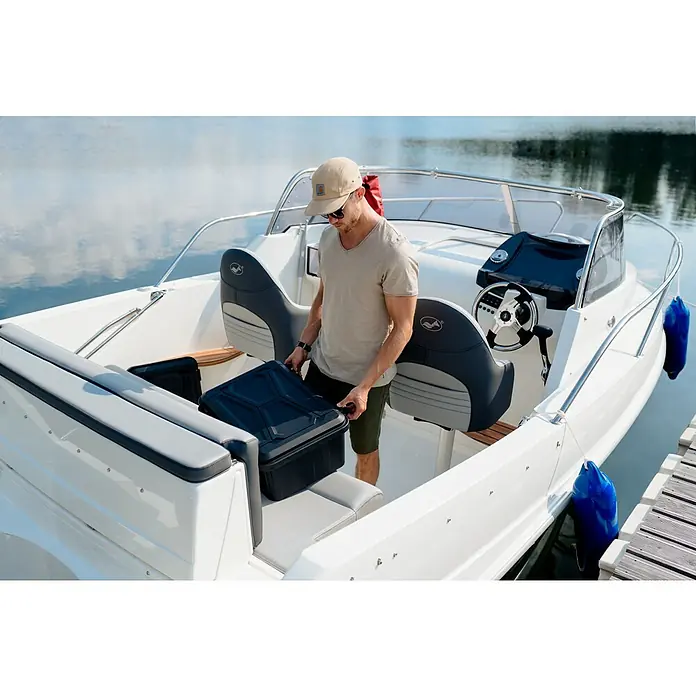 Wasserdichter Koffer EKO90 - L x B x H: 520 x 350 x 125 mm, Ohne Schaumstoffeinlage, Grau, Kunststoff - Ein Mann verstaut eine schwarze Aufbewahrungsbox in einem weißen Motorboot auf einem See.