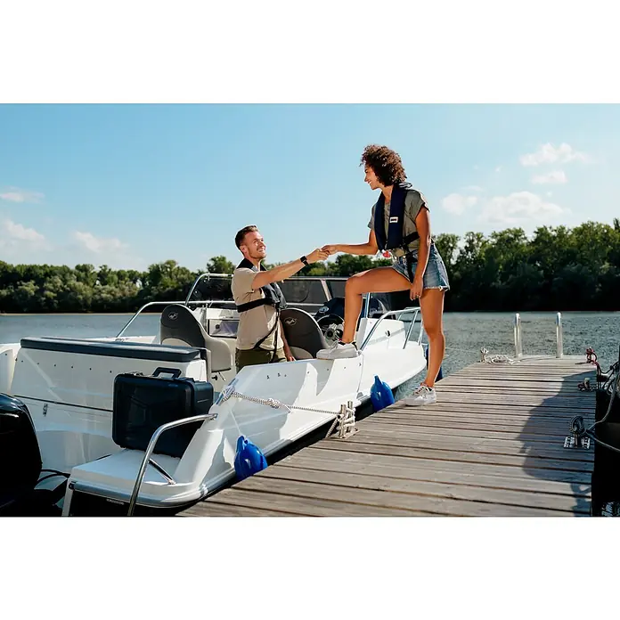 Wasserdichter Koffer EKO90 - L x B x H: 520 x 350 x 125 mm, Ohne Schaumstoffeinlage, Grau, Kunststoff - Ein Paar hilft sich gegenseitig beim Einsteigen in ein weißes Motorboot am Dock, beide tragen Schwimmwesten.