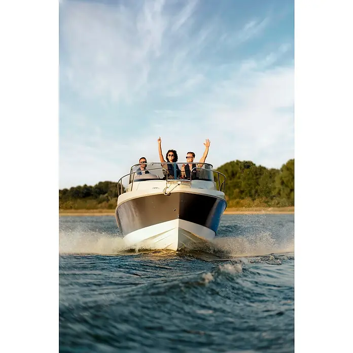PEGAZUS GFK-Boot 550 Comfort - Umfangreiche Zusatzausstattung, Geeignet für: Max. 6 Personen, Nutzlast: 670 kg, CE-Klasse C - Drei Personen genießen eine Fahrt mit einem stilvollen Motorboot auf dem Wasser, Hände in der Luft, während das Boot Wellen schlägt.