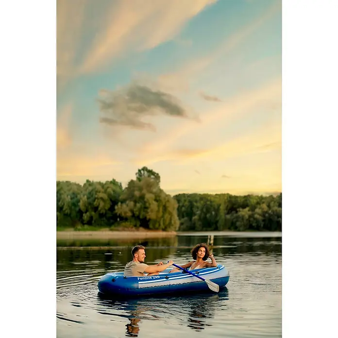 Talamex Schlauchboot Funline 240 - 240 x 140 cm, Geeignet für: 2 Personen, Nutzlast: 165 kg - Ein Paar genießt eine entspannte Bootsfahrt in einem blauen Funline Z40 Schlauchboot auf einem ruhigen See bei Sonnenuntergang.