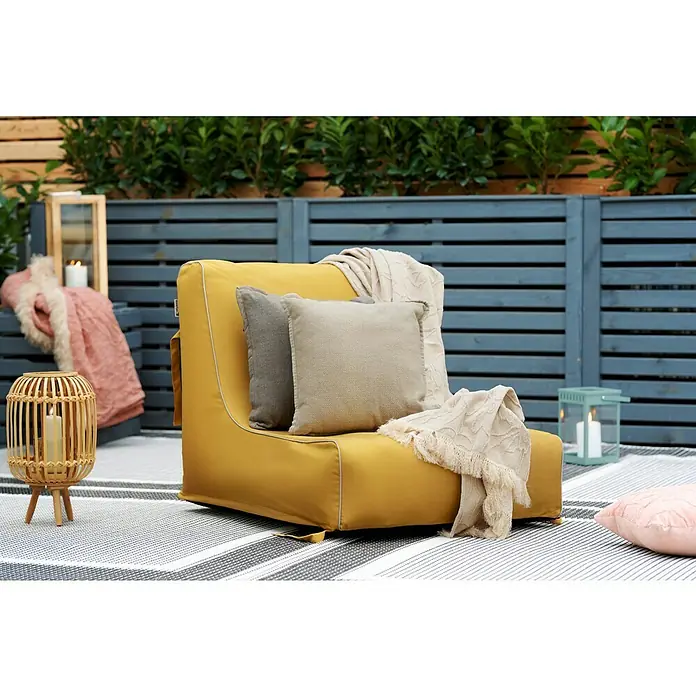Sitzsack Aufblasbar - 70 x 90 x 70 cm, Gelb, 100 % Polyester - Gelber Sitzsack mit Kissen und Decken auf einer Terrasse mit grauem Holzzaun.
