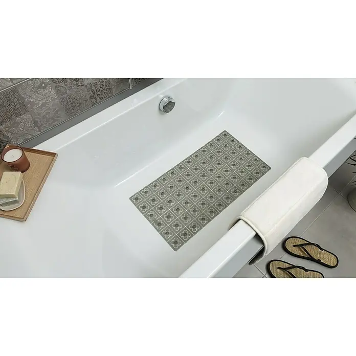 Tatay Alfombra antideslizante para ducha BCN - 36 x 72 cm, PVC, Antracita - Una alfombra de baño gris estampada se encuentra dentro de una bañera blanca junto a jabón, una vela y chanclas.
