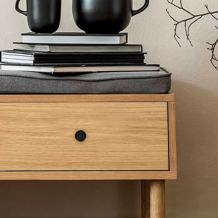 Häfele Pomo para muebles - Tipo de tirador del mueble: Botón, Ø x Al: 30 x 23 mm, Marrón - Mesita de noche de madera clara con cajón y pomo negro, con libros y tazas encima.