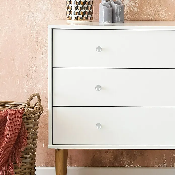 Häfele Pomo para muebles - Tipo de tirador del mueble: Botón, Ø x Al: 25 x 22 mm, Cromado - Cómoda luminosa con tres cajones y pomos redondos. En la parte superior hay objetos decorativos, al lado una cesta con una manta.