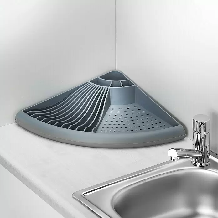 Wenko Geschirrkorb - L x B x H: 35 x 50 x 9 cm, Grau - Grauer dreieckiger Kunststoff-Eckabflusskorb mit Schlitzen für Geschirr und Fächern für Besteck, in einer Küchenecke neben der Spüle.