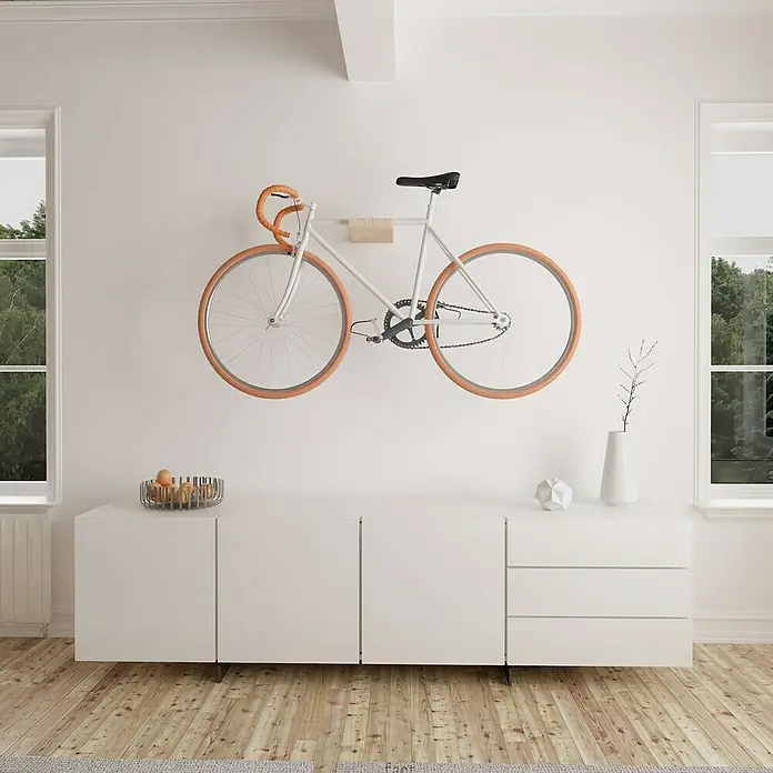 Rei Fahrradhalterung - L x B x H: 35 x 20 x 10 cm, Belastbarkeit: 25 kg - An der Wand montiertes weißes Fahrrad mit braunen Reifen, das Eleganz und Funktionalität im Raum vereint.